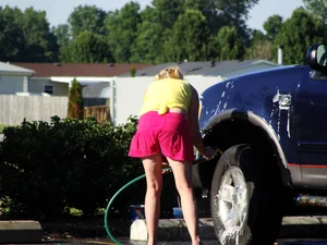 Group of cute girls at a car wash in bikinis and shorts