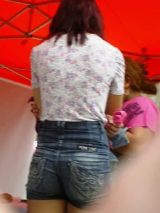 Redhead girl with her cheeks eating her denim shorts