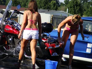 Group of cute girls at a car wash in bikinis and shorts
