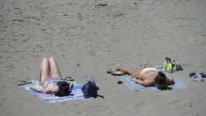 Sexy beach girl laying out in white bikini with nice body