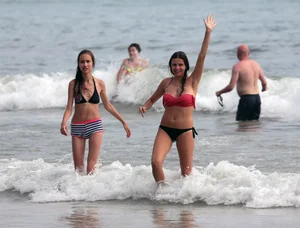 Skinny small boobed girl in a bikini on the beach with her friend