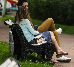 Girl in Sandals Sitting on the Park Bench With Crossed Legs