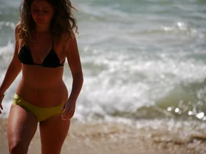 Sexy girl in yellow and black bikini on the beach