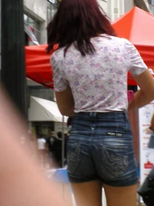 Redhead girl with her cheeks eating her denim shorts