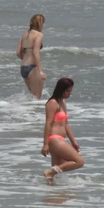 Thick girl in orange bikini playing on the beach