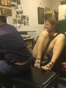 Candid Girl in Mini Shorts And Sandals Sitting With Her Feet on Chair Laughing
