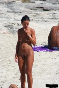 Smoking milf at a nude beach with a hairy pussy