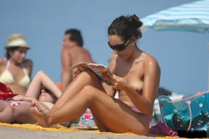 2 topless girls at the beach in thongs