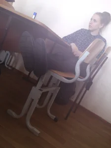 College Girl With Slim Legs Sitting On Two Chairs in Class