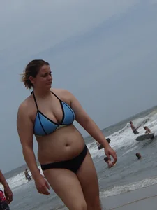 Big boobed girl on the beach in blue and black bikini