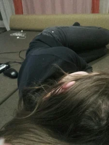 Cute teen in tight jeans curled up on a couch at home