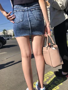 Cute Girl in a Short Denim Skirt Walking on a Street And Waiting on a Crosswalk Gallery