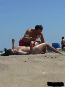 Purple thong topless lady on the beach gets oiled up by her husband