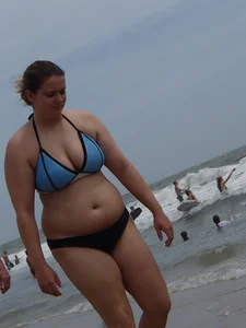 Big boobed girl on the beach in blue and black bikini