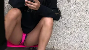 Asian girl in shorts sitting with her legs open