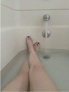 Candid Girl Lying in a Bath With Crossed Legs Selfie