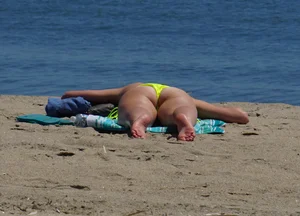 Sexy ass blonde milf on the beach in a thong with cameltoe and bending over