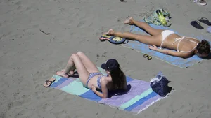 Sexy beach girl laying out in white bikini with nice body
