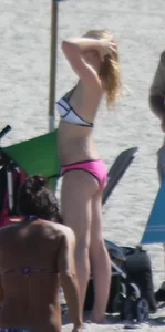 Skinny blonde girl on the beach in her pink and white bikini