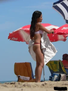 Hot brunette ethnic girl on the beach in a pink thong bikini
