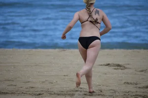 Chunky blonde in a black bikini on the beach