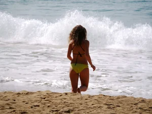 Sexy girl in yellow and black bikini on the beach