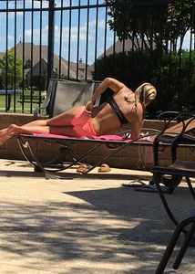 Blonde at the pool and laying out in peach and black bikini combo