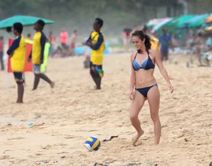 Hottie bikini babe on the beach kicking around a volleyball
