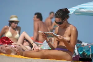 2 topless girls at the beach in thongs
