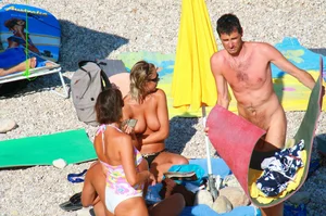 Nudist couple on the beach, girl has amazing tits and nice ass in a thong