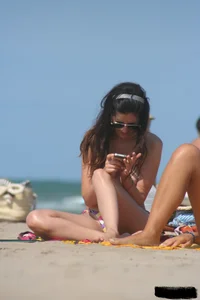 2 topless girls at the beach in thongs