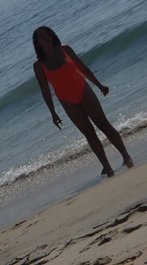 Beach girl with big boobs in an orange swimsuit