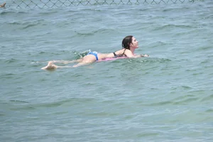Skinny and sexy brunette on the beach in black and blue bikini