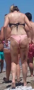 Chunky beach blonde babe in a pink thong bikini