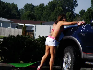 Group of cute girls at a car wash in bikinis and shorts