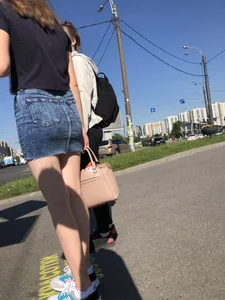Cute Girl in a Short Denim Skirt Walking on a Street And Waiting on a Crosswalk Gallery