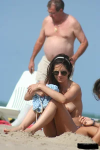 2 topless girls at the beach in thongs