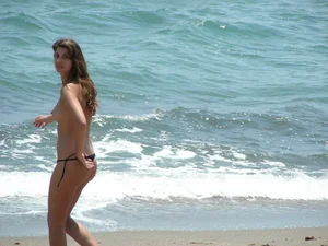 Topless girl with tan lined tits and in a black thong bikini