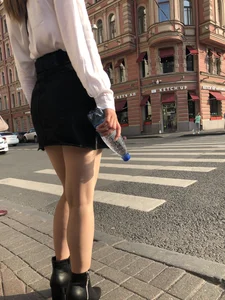 Awesome candid chick wearing a blouse and a skirt crossing the street on high heels, showing a little cheek