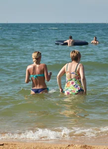 Sexy blonde milf on the beach in blue thong bikini and showing nice camel toe