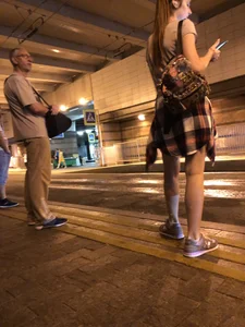 Cute Teen in Shorts on the Tram Stop