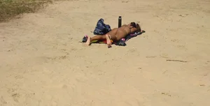 Sexy girl getting some sun laying on the beach in thong bikini