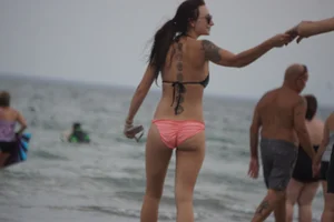 Peach bikini tattood babe on the beach with a nice ass and some camel toe