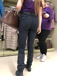 Cute candid shop assistant wearing boots and tight pants
