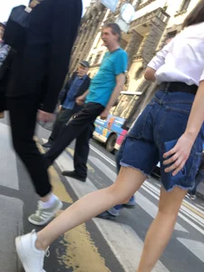 Candid girl wearing denim shorts crossing the street, sexy slim legs