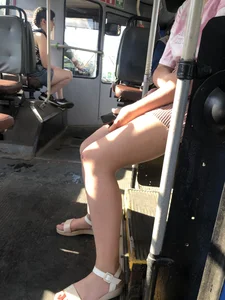 Young Girl in Sandals and Shorts in a Public Bus