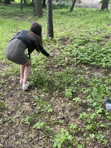 Skinny girl in a short dress bending over to feed a squirrel