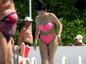 Smoking brunette in pink thong at the pool with camel toe