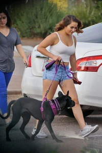Sexy dog walker in shorts and tank top with friend in blue jeans