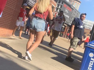 Bunch of girls in various outfits at a Cardinals baseball game